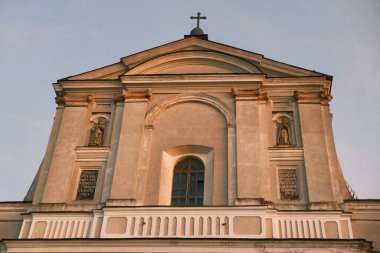Ancient Cathedral of the St. Peter and Paul. White wall of an old cathedral with windows and statues. Ancient catholic cathedral and its statues in the windows
