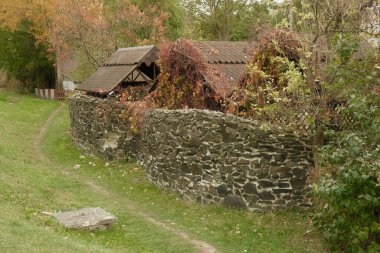 Köydeki evin yanında güzel taş çitler var. Köydeki antik siyah taş tarzında bir çit ve yakınında bir çim..