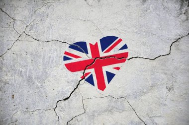 Büyük Britanya bayrağı çatlamış beton bir duvardaki kalbi simgeler. Kavram.