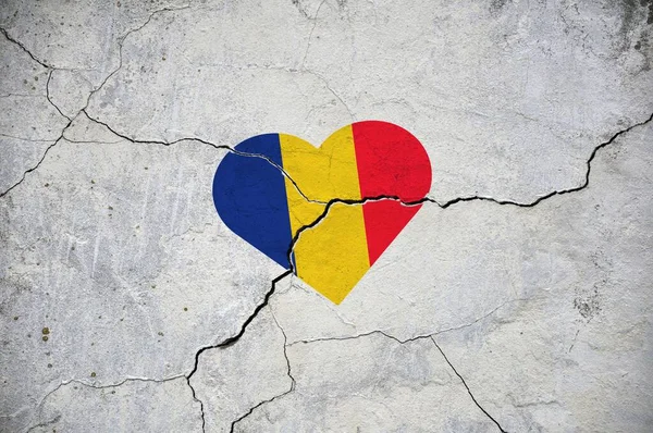 Kırık beton bir duvarda, Romanya 'nın ulusal bayrağının bir kalp şeklinde sembolü. Kavram.