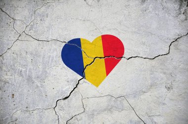 Kırık beton bir duvarda, Romanya 'nın ulusal bayrağının bir kalp şeklinde sembolü. Kavram.