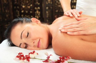 Genç kadın masaj yaptırıyor.