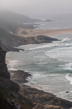 Güney Afrika 'daki Bahçe Yolu' ndaki Robberg Doğa Rezervi 'nin kayalık ve sisli kıyı şeridi.