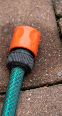 Bir hortumun sonu ve dışarıda asfalt bir yüzey üzerinde nemli bir nokta.