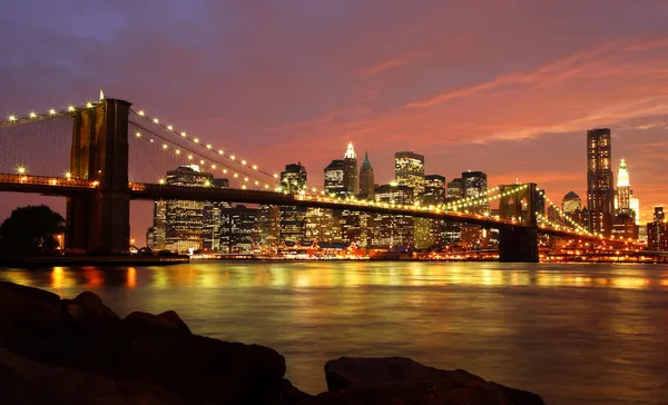 Brooklyn Bridge and New York Skyline at Night Royaltyfria Stockbilder