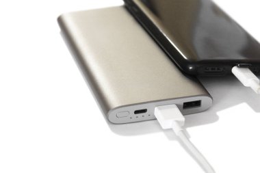 Akıllı telefon dış güç bankasından kabloyla şarj oluyor. Beyaz arkaplan, yakın plan, seçici odak