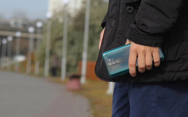 A man with a smartphone in his hand on the embankment of the city 