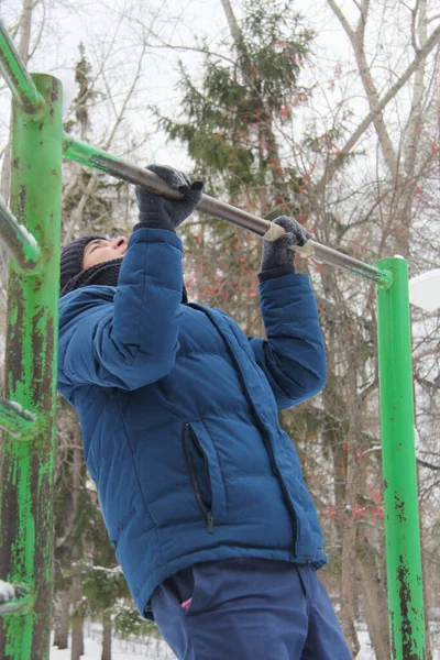 A guy performing a sporting activity on a street playground