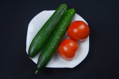 Domatesler, salatalıklar ve koyu bir arka plan. Sağlıklı yemek. 