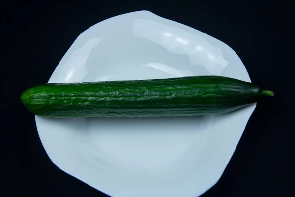 Siyah arka planda yeşil salatalık. Sebzeler