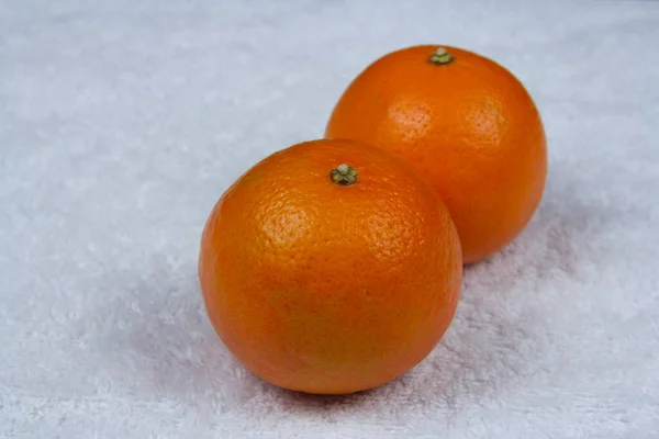 Festive ripe tangerines on a white towel 