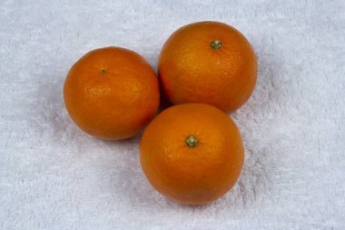 Ripe tangerines on a white terry towel