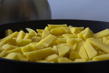 Mutfaktaki tavada kızarmış altın patatesler. 