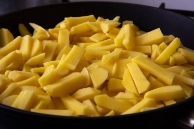 Mutfaktaki tavada kızarmış altın patatesler. 