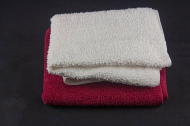 Kırmızı ve beyaz havlu siyah bir yüzeye uzanıyor.