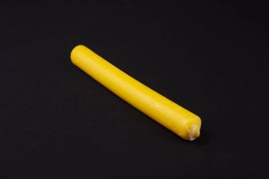 Parlak turuncu bir mum siyah bir bezle bir masanın üzerinde yatıyor.