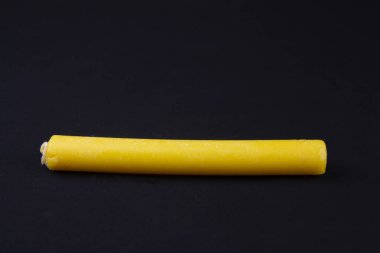 Parlak turuncu bir mum siyah bir bezle bir masanın üzerinde yatıyor.