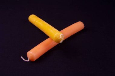 Parlak turuncu bir mum siyah bir bezle bir masanın üzerinde yatıyor.