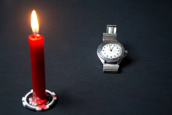 Eine Armbanduhr Und Eine Rote Kerze Auf Schwarzem Hintergrund — Stockfoto