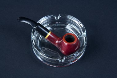 Siyah arka planda sigara piposu ve kül tablası