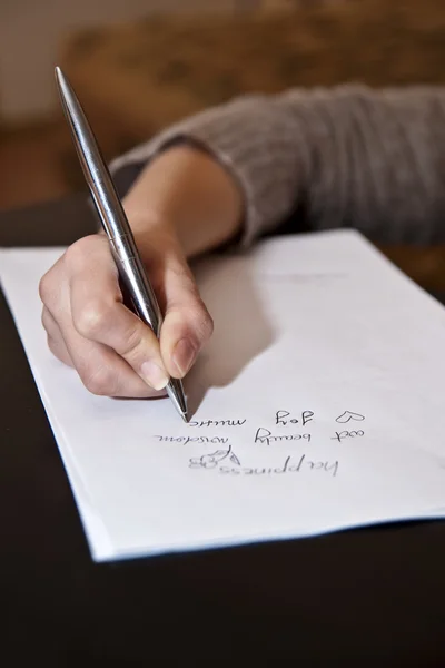 Hand skriva på vitt papper med brun bakgrund Stockfoto