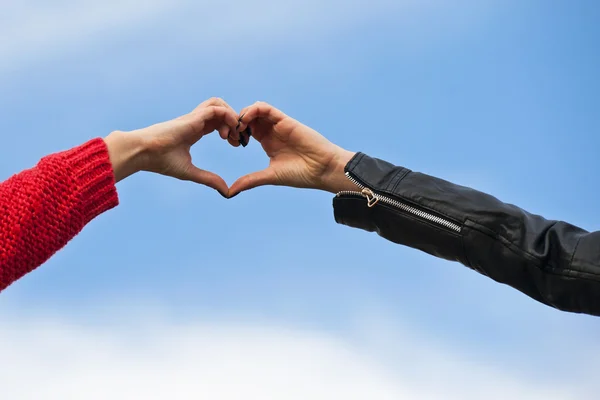 Forma del corazón hecha por manos femeninas Imagen de stock