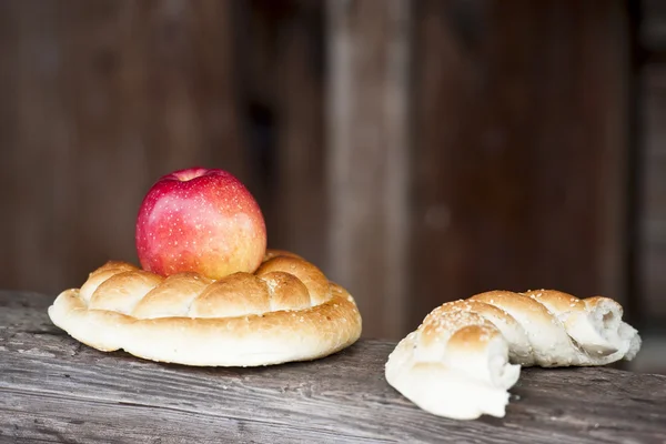 Manzana roja y pretzel sobre fondo rústico de madera —  Fotos de Stock