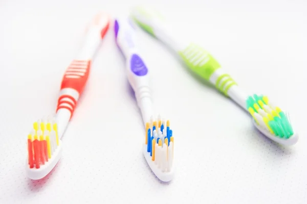 Τρεις οδοντόβουρτσες είναι στο ράφι. — Φωτογραφία Αρχείου