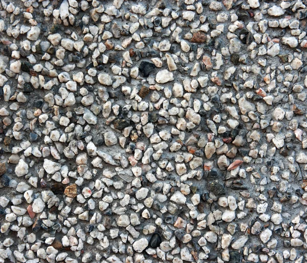 La pared con piedras muy pequeñas. Fondo de piedras . — Foto de Stock