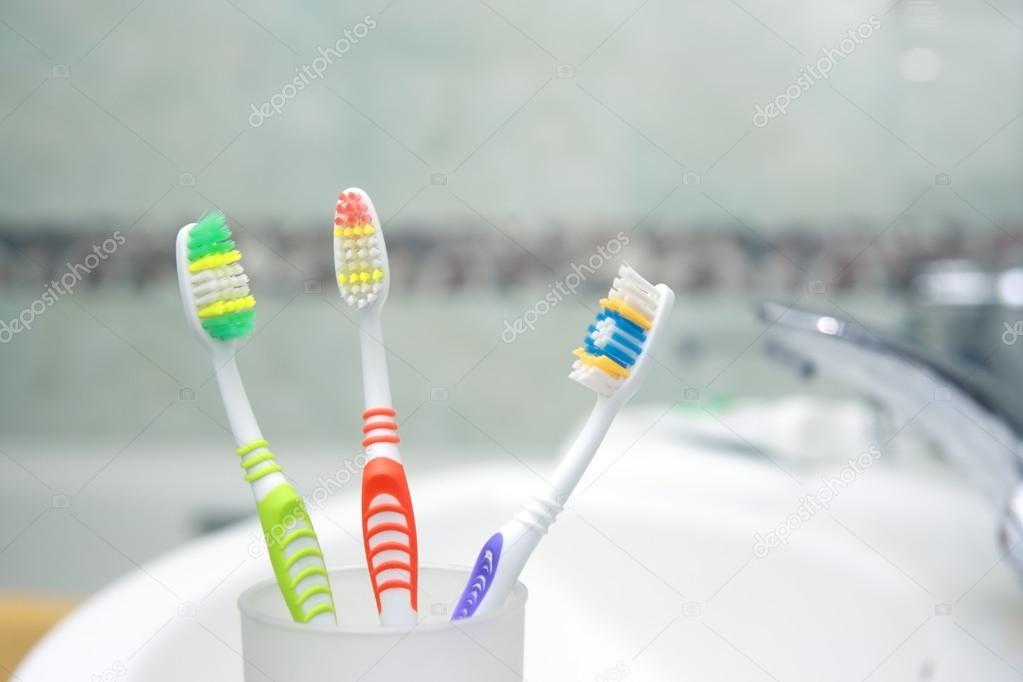 Three Toothbrushes in a bathroom. Close up shot of toothbrush.