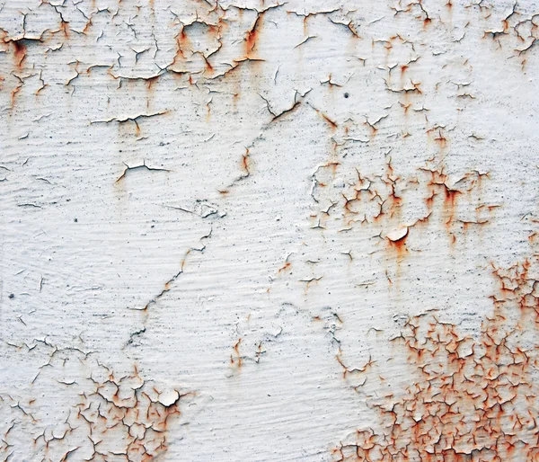 A rusty old metal plate with cracked white gloss paint. Old rust