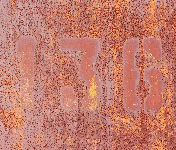 Numbers 1, 3, 6 on rusty iron wall.