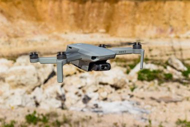 Küçük drone DJI Mini 2 kayalık bir arazinin arka planına karşı uçuyor: Rusya - Mayıs 2021