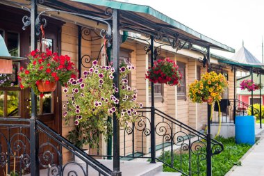 Verandayı süsleyen saksılarda asılı çiçekler.