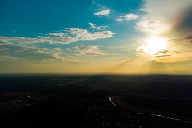 Dünyanın büyük bir yüksekliğinden, ufuktan ve mavi gökyüzünden bak. Güneşin ışınları yaklaşan bulutları delip geçiyor.