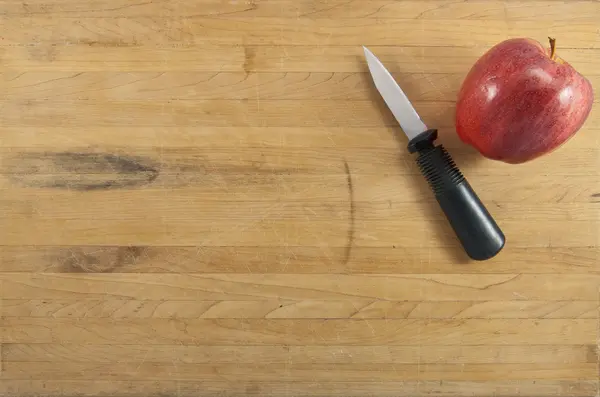 Manzana y cuchillo en la tabla de cortar — Foto de Stock