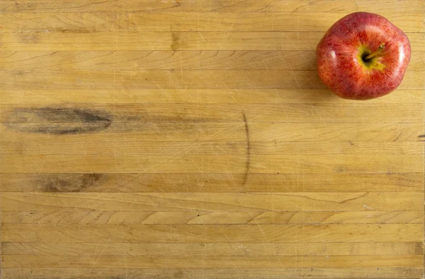 Manzana roja en la tabla de cortar gastada — Foto de Stock