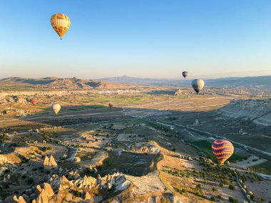 Kapadokya, Türkiye üzerinde renkli balonlar uçuyor. Güneş doğarken sıcak hava balonu uçuşu.