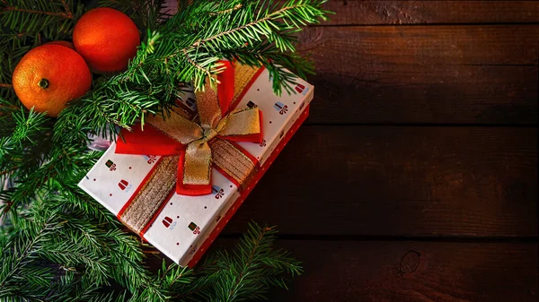 Рождественский подарок с мандаринами и еловой ветвью — стоковое фото