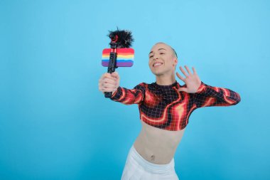 Gülümseyen ve mutlu ikili olmayan sosyal etkiye sahip kişi bir cep telefonuyla çevrimiçi video blogluyor.