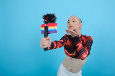 İkili olmayan kişi çevrimiçi yayınlanırken veya bir vlog için video kaydederken cep telefonu kamerasına öpücük gönderiyor.