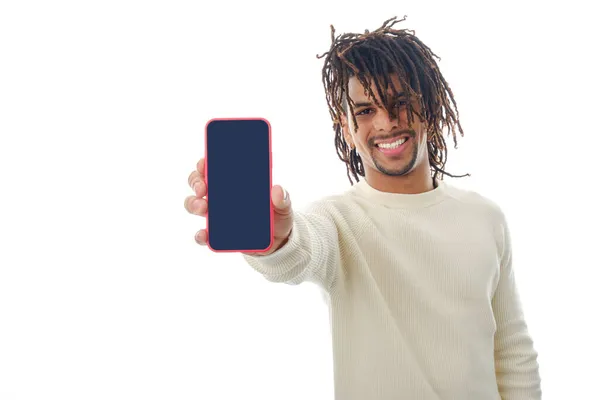 Hombre latino mostrando la pantalla en blanco del teléfono móvil a la cámara mientras está de pie sobre un fondo aislado. —  Fotos de Stock
