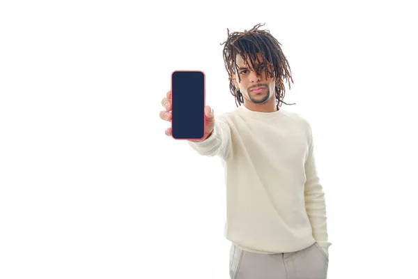 진지 한 남자가 외딴 배경 위에서 서 화면에 빈 휴대폰을 보여 주며 카메라 앞에 서 있는 모습. — 스톡 사진