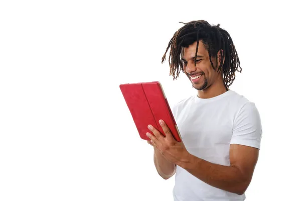 Latin man smiling while using a digital tablet over an isolated background. Stock Image