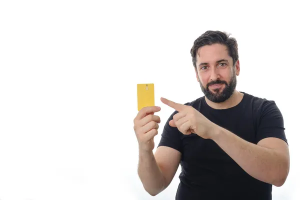 Hombre mostrando y señalando con el dedo a la tarjeta de crédito mientras está de pie sobre un fondo aislado. —  Fotos de Stock