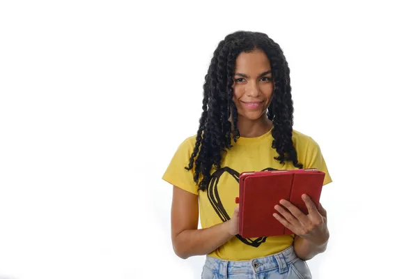 Mujer latina sonriente usando una tableta digital mientras está de pie sobre un fondo aislado. —  Fotos de Stock