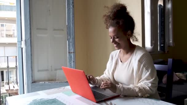 Evde çalışırken bir masada oturan bir kadın bilgisayar kullanıyor. İş ve serbest meslek kavramı. — Stok video
