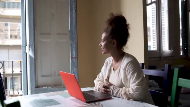 Kobieta relaksująca się i korzystająca z laptopa siedząc na stole podczas pracy w domu. Praca w domu koncepcja — Wideo stockowe