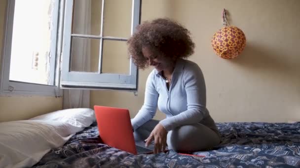 Evde bir yatakta yatarken bilgisayarını kullanan bir kadın. İş ve teknoloji kavramı. — Stok video