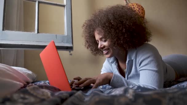 Femme écrivant sur son ordinateur portable à la maison couchée sur son lit - concept de travail à la maison — Video